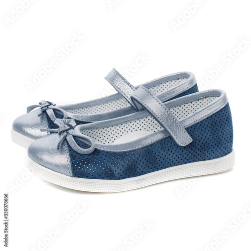 Children's blue shoes for girls with silver inserts and a silver bow isolated on white. Side view
