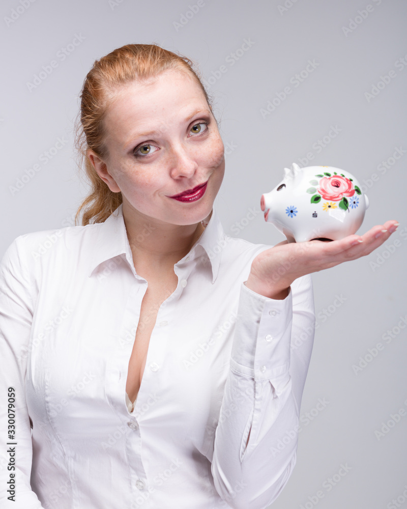 young sexy red haired woman presents her piggy bank young sexy red haired woman presents her piggy bank