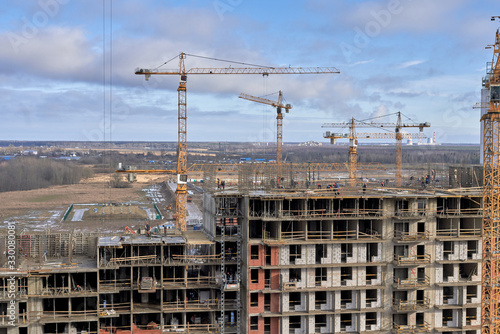 Wallpaper Mural A lot of builders in helmets and masks on the top floor of a house under construction Torontodigital.ca