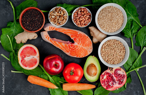 Selection of healthy food  salmon  fruits  seeds  cereals  superfoods  vegetables  leafy vegetables on a stone background. Healthy food for people.