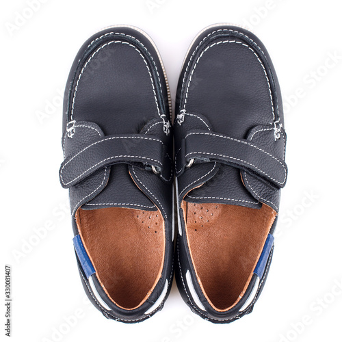 Children's black leather shoes for boys isolated on white. Top view