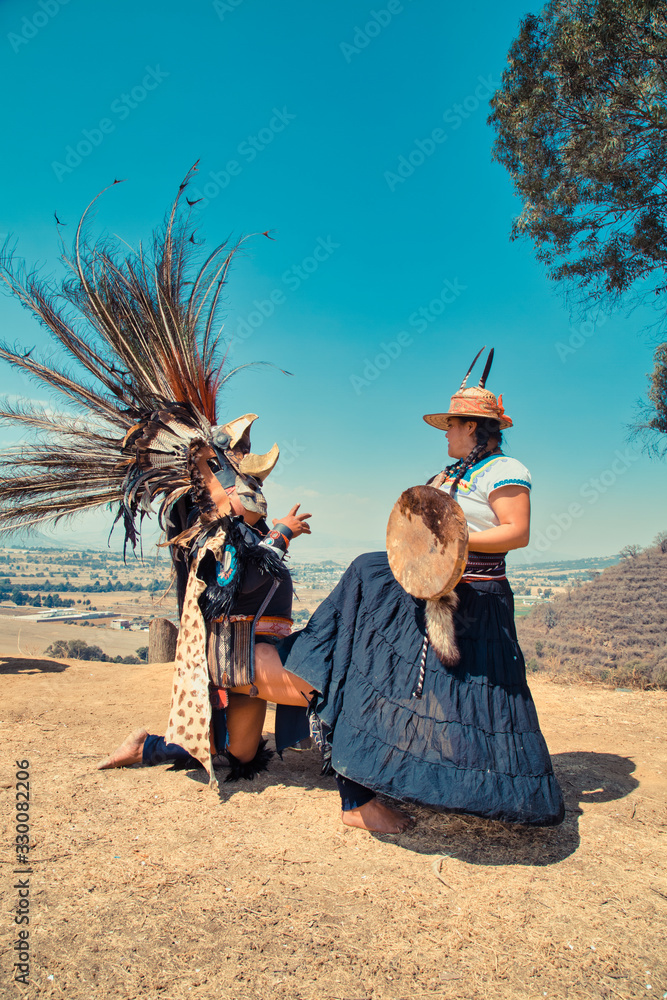 Mexican dancers posing at camera with tufts and pre-Hispanic dress