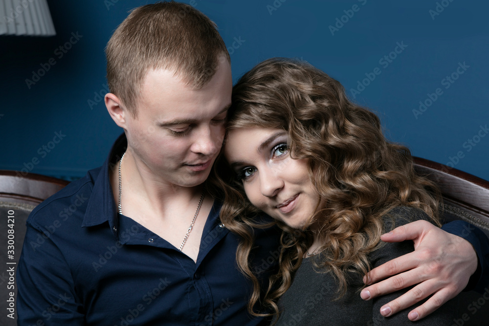 The guy and the girl are sitting embracing. A young couple. Lovers. A man takes on a beautiful woman. The guy and the girl are sitting embracing. A young couple. Lovers. A man takes on a beautiful woman.