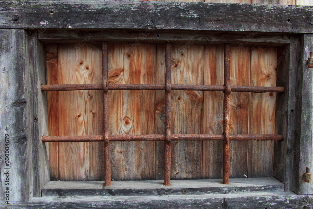 Cravegna (VCO), Italy - December 19, 2017: An old window with a iron grate, Vigezzo Valley, VCO, Piedmon, Italy Cravegna (VCO), Italy - December 19, 2017: An old window with a iron grate, Vigezzo Valley, VCO, Piedmon, Italy