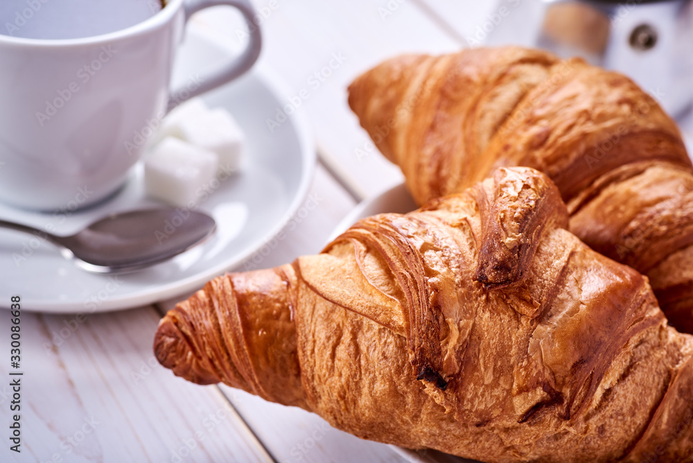 Continental or French breakfast. Croissants and cup of black coffee with sugar and spoon. Continental or French breakfast. Croissants and cup of black coffee with sugar and spoon.