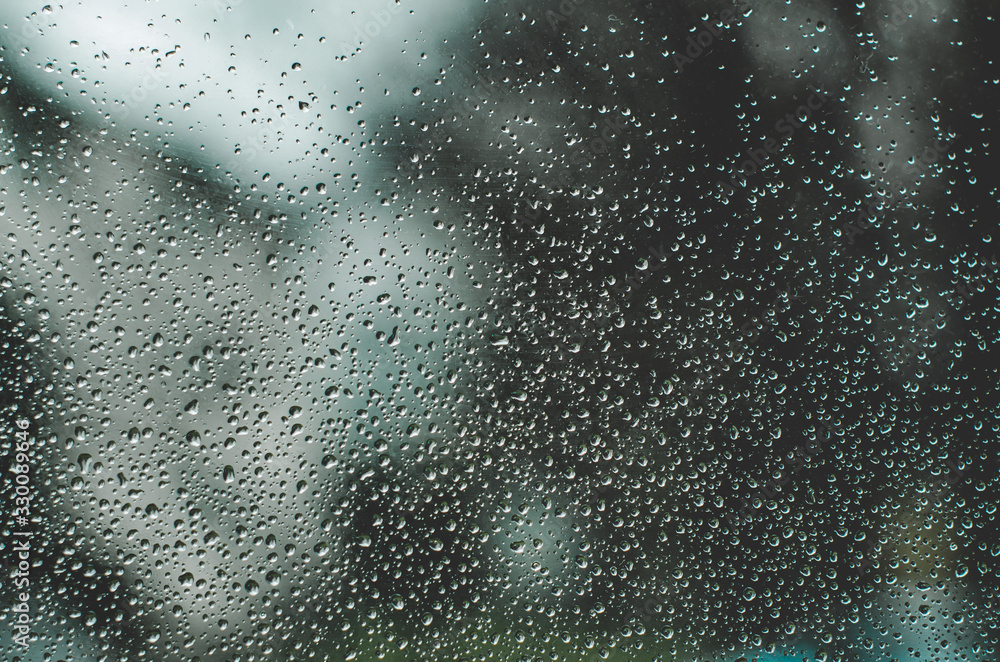 Water drops on windows close up against blurry background Water drops on windows close up against blurry background