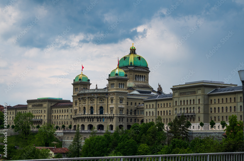Fototapeta premium Parliament building in Bern city Switzerland overcast day dramatic clouds summer