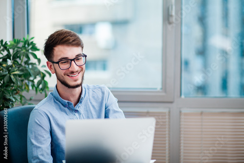 Young businessman in office working on laptop © Suteren Studio