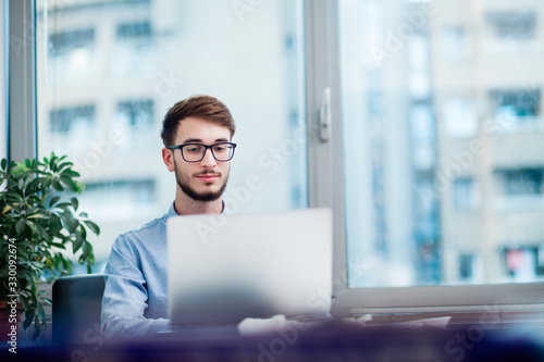 Young businessman in office working on laptop