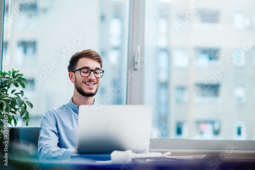 Young businessman in office working on laptop Fototapet