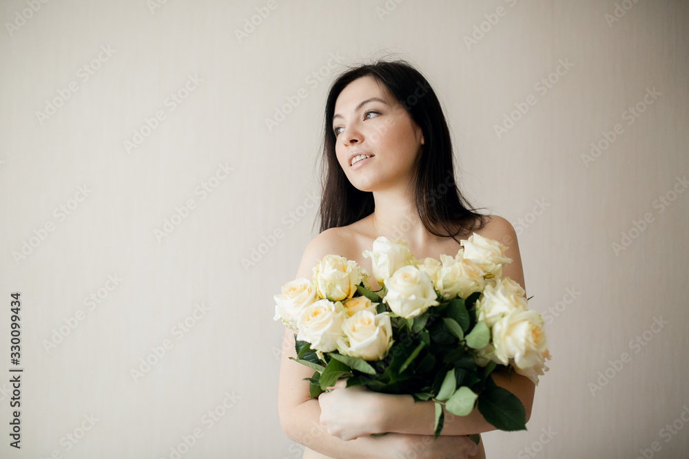 Portrait of an attractive young woman holding bouquet of roses. Portrait of an attractive young woman holding bouquet of roses.