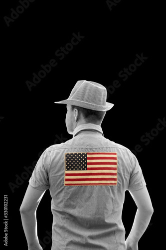 Man in hat and shirt with American flag on his back, vertical isolated on black