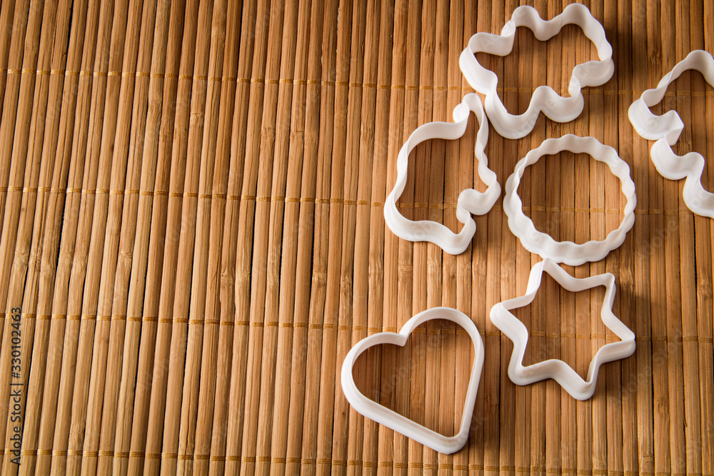 plastic molds for baking cookies in the form of hearts, stars, circle, elephant, hippo and bear, on wooden background plastic molds for baking cookies in the form of hearts, stars, circle, elephant, hippo and bear, on wooden background