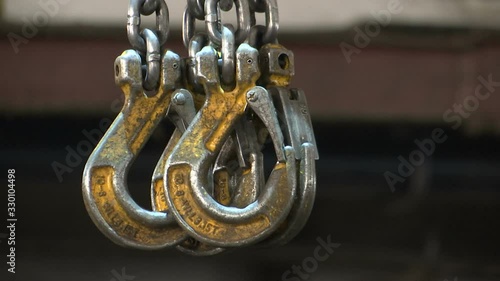 Chain slings are suspended on the hook of the crane.