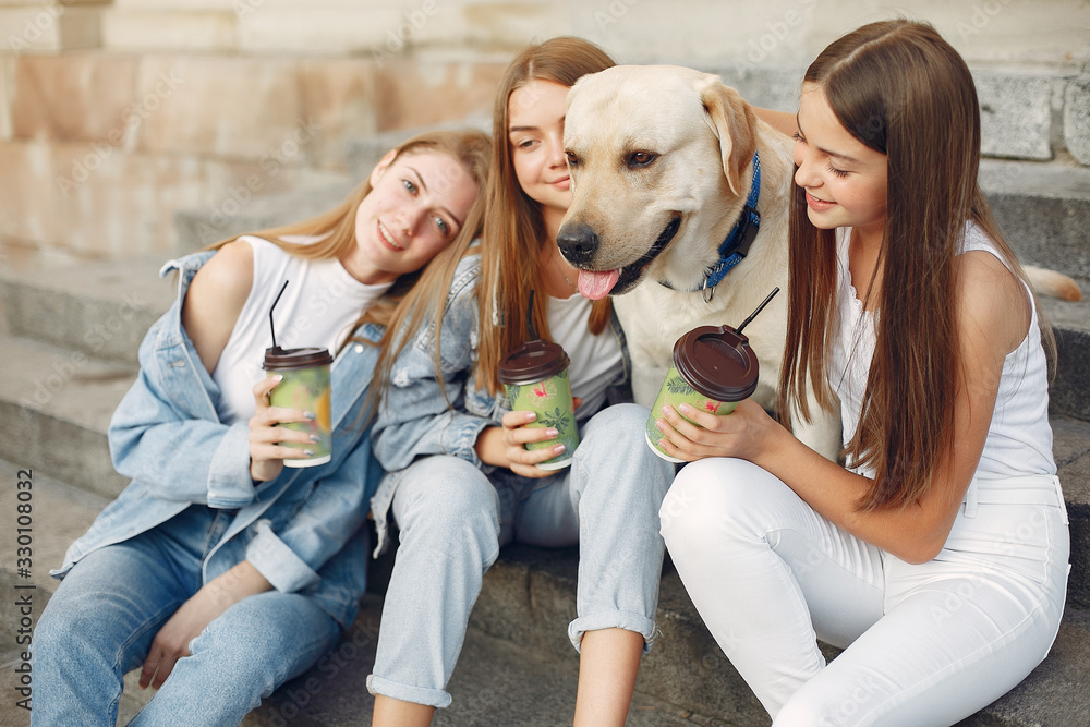Beautiful girls drinking a coffee. Women in a spring city. Ladies with cute dog. Beautiful girls drinking a coffee. Women in a spring city. Ladies with cute dog.