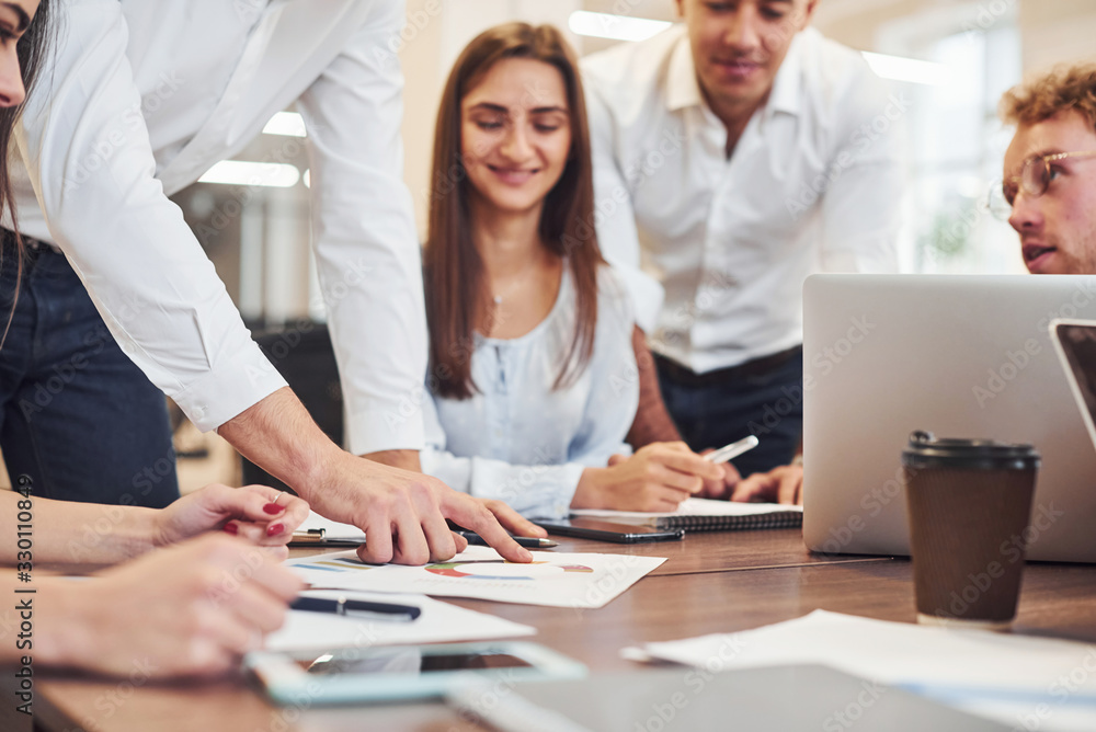 Sitting by the table. Young business people working together in the modern office Sitting by the table. Young business people working together in the modern office