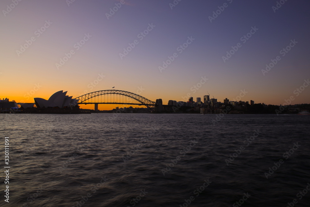 Panorama View of Sydney Harbour bridge on a warm summer afternoon blue and orange skies illuminating Sydney Harbour Bridge