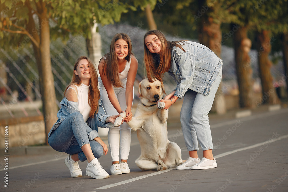 Fototapeta premium Beautiful girls walking. Women in a spring city. Ladies with cute dog.