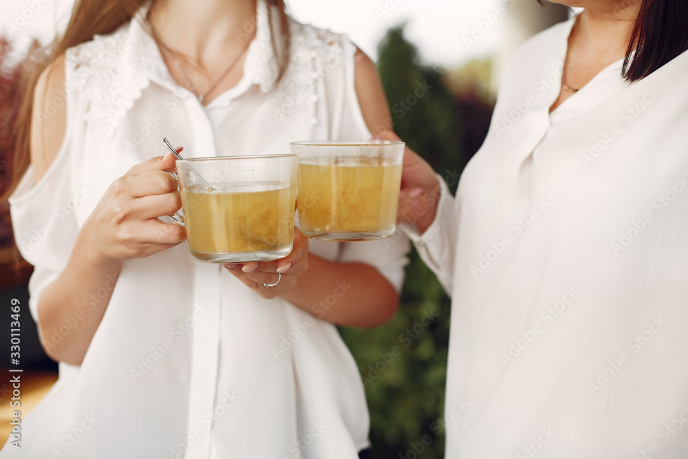 Beautiful women in a cafe. Mother with daughter drinking a tea. Lady in a white shirt. Beautiful women in a cafe. Mother with daughter drinking a tea. Lady in a white shirt.