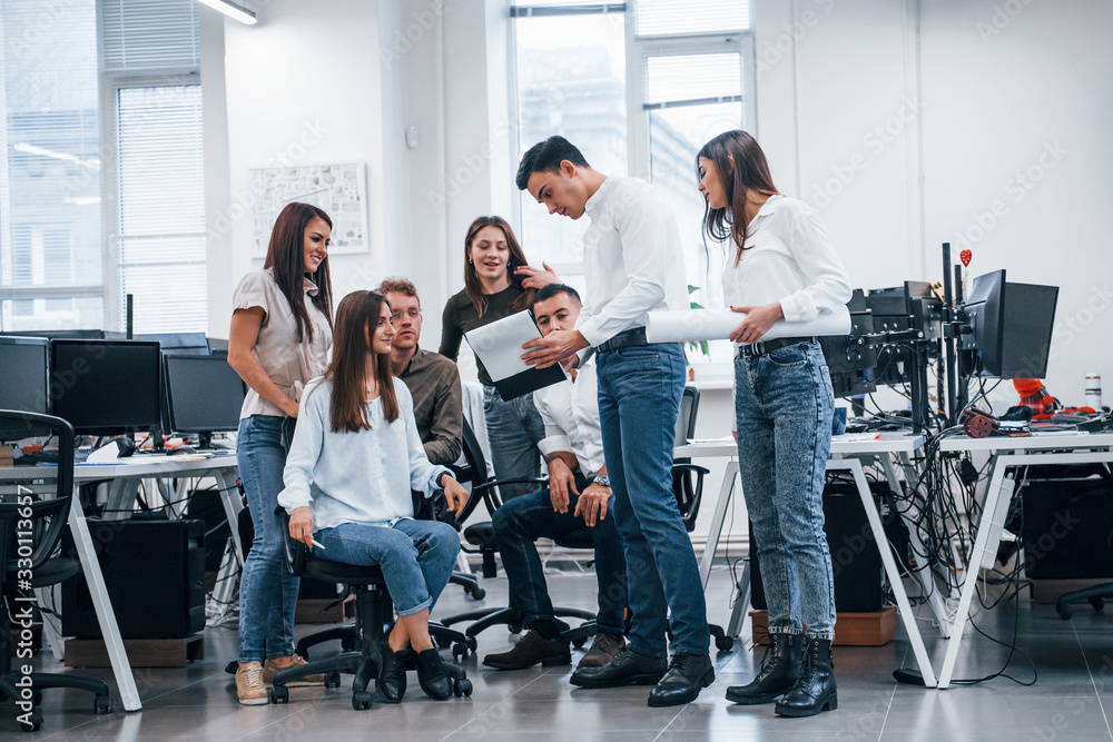 Group of young business people that standing and sitting and working in the office Group of young business people that standing and sitting and working in the office