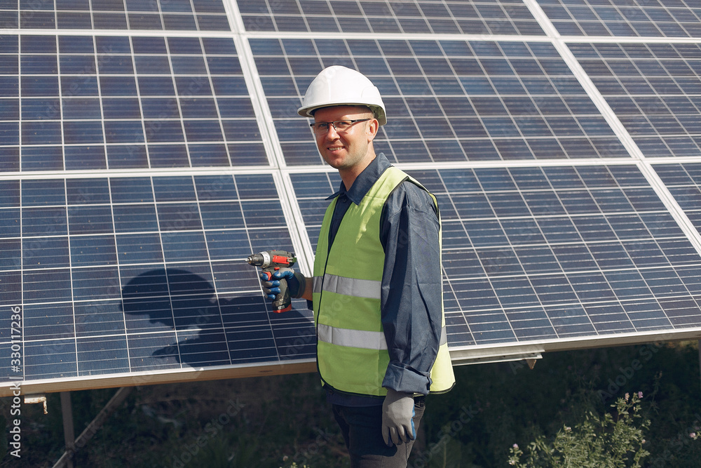 Engineer in a white helmet. Man near solar panel. Engineer in a white helmet. Man near solar panel.