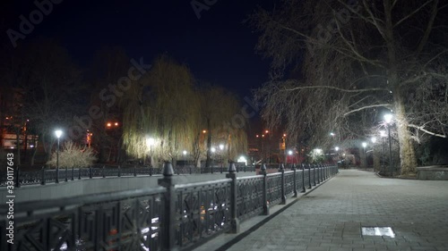 Empty city river embankment lit by lanterns at night in autumn. Salgir River Embankment in Simferopol. photo