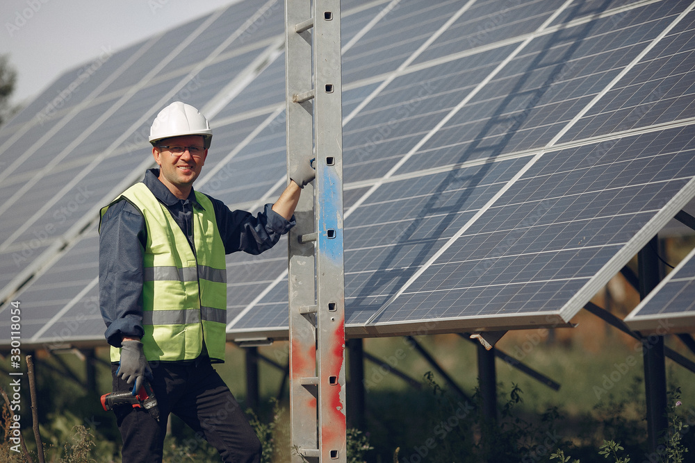Engineer in a white helmet. Man near solar panel. Worker with a ladder Engineer in a white helmet. Man near solar panel. Worker with a ladder