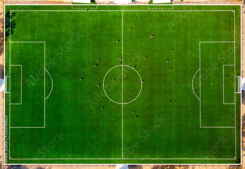 Aerial drone top view of mini football soccer field with playing people.