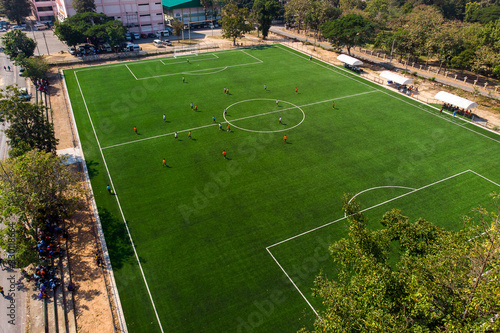 Aerial drone top view of mini football soccer field with playing people.