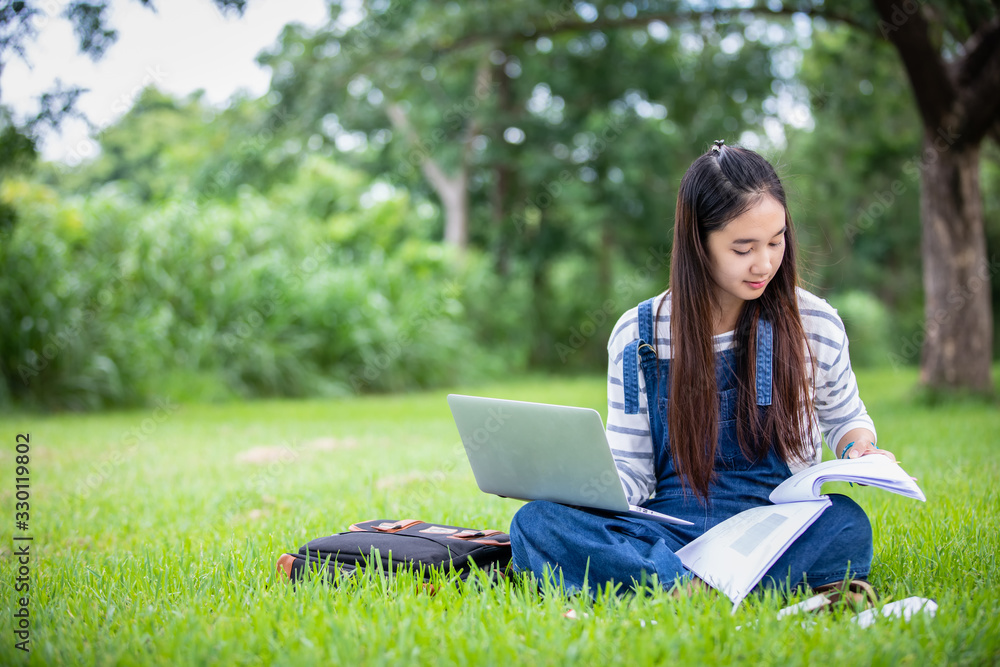 beautiful Asian girl student holding books and smiling at camera and learning and education concept on park in summer for relax time beautiful Asian girl student holding books and smiling at camera and learning and education concept on park in summer for relax time