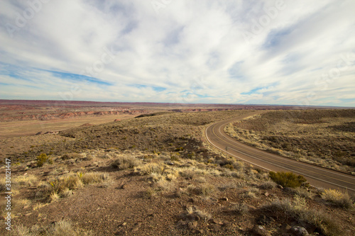 Road To Nowhere. Remote empty desert blacktop road winds through a barren landscape in the American Southwest.