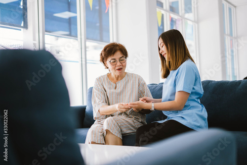 Young doctor consulting senior patient at health care clinic 