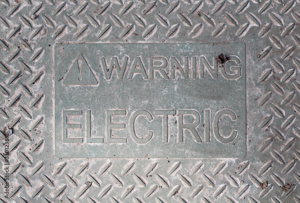 A close view of the metal electric warning sign.