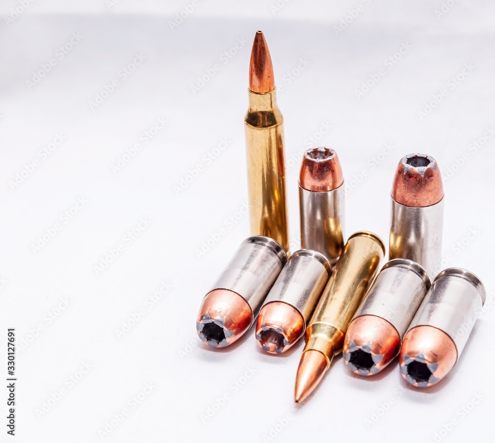 Four different caliber bullets, 223 rifle bullets, 9mm, 40 caliber and 45 auto on a white background Four different caliber bullets, 223 rifle bullets, 9mm, 40 caliber and 45 auto on a white background