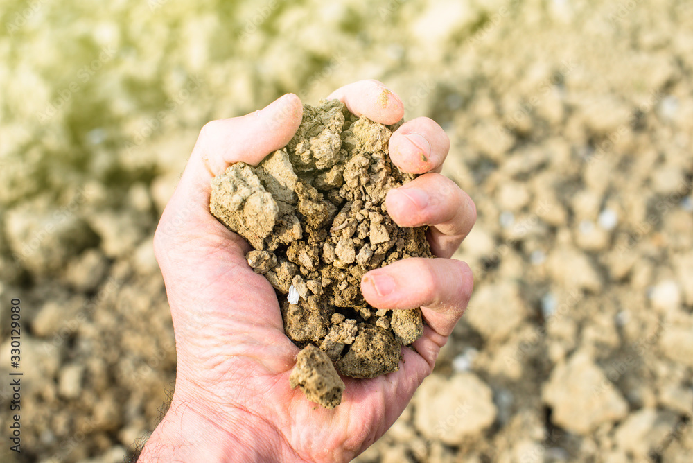 Handful of arable soil in hand of responsible farmer Handful of arable soil in hand of responsible farmer