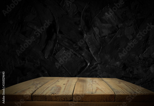 Empty wooden table in front of abstract dark wall background. Can be used to display or edit your products.