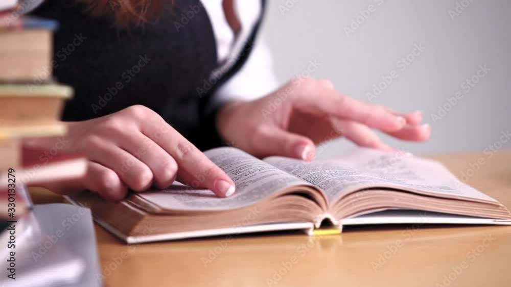 Caucasian female college student reading book in library Caucasian female college student reading book in library