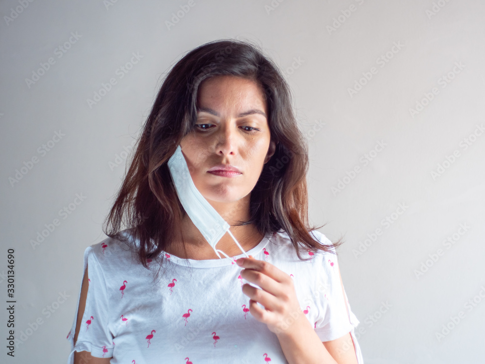 Young Attractive Brown Hair Hispanic/Latin Woman Wears a Disposable Face Mask for Cough, Flu, Virus, Viral Protection Young Attractive Brown Hair Hispanic/Latin Woman Wears a Disposable Face Mask for Cough, Flu, Virus, Viral Protection
