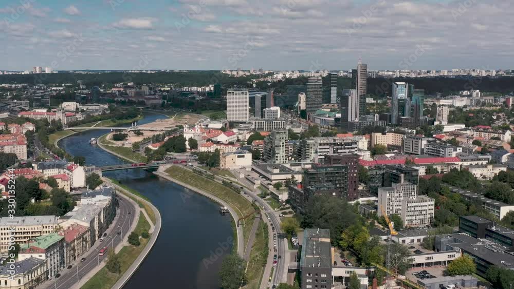 VILNIUS, LITHUANIA - JULY, 2019: Aerial view of the Neris river crossing the industrial and ancient quarters of Vilnius. VILNIUS, LITHUANIA - JULY, 2019: Aerial view of the Neris river crossing the industrial and ancient quarters of Vilnius.