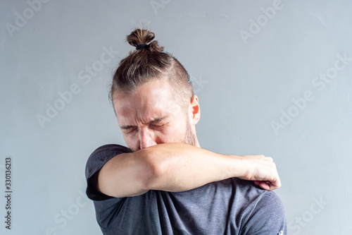 Young Blond Hair Caucasian Male Sneezing on his Arm