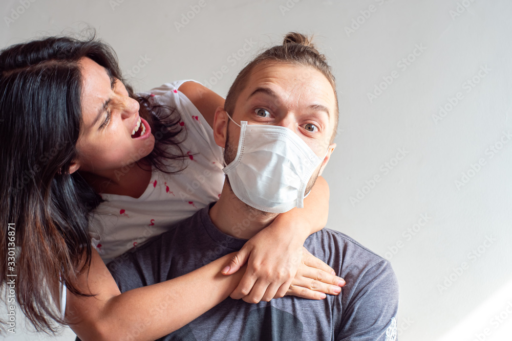 Angry Latin Woman Yells at Young Blond Hair Caucasian Male Using Disposable Face Mask for Covid-19, Cought, Flu, Virus, Viral Protection