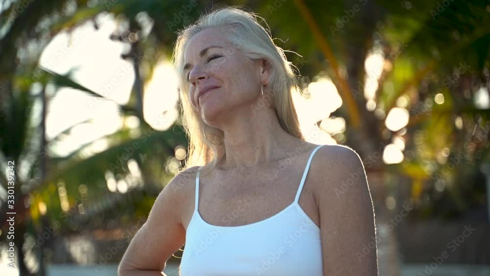 Closeup intimate portrait of pretty, mature, woman as she takes a large breath and looks serenely at camera. Closeup intimate portrait of pretty, mature, woman as she takes a large breath and looks serenely at camera.