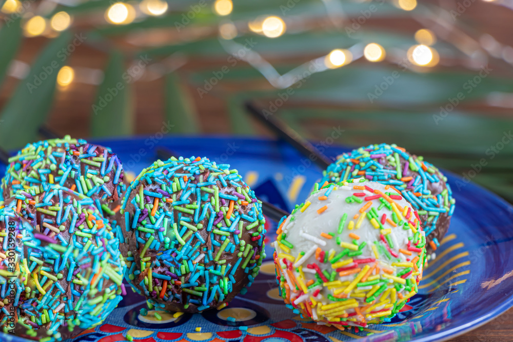 A colorful cake pops up, lying on a table. It is covered with sweet multi-colored sweets.