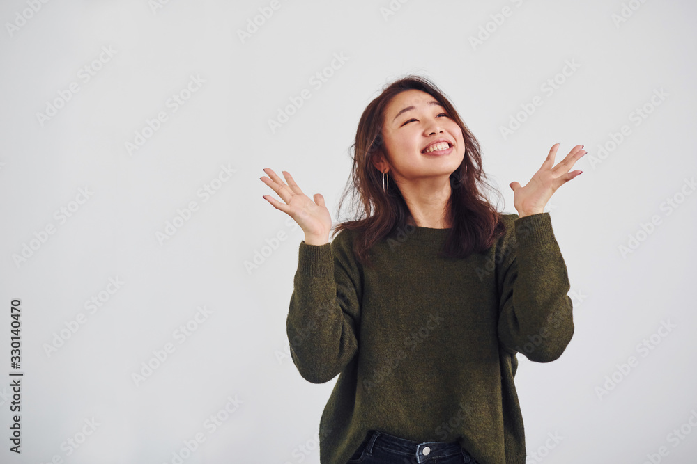 Portrait of happy asian young girl that standing indoors in the studio against white background Portrait of happy asian young girl that standing indoors in the studio against white background