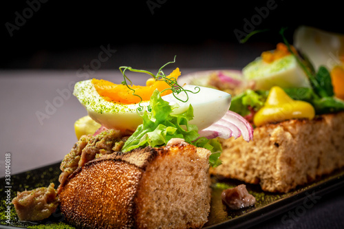Bruschetta with tuna and herbs on black bread toast with egg. Delicious homemade food. restaurant menu. place under the text