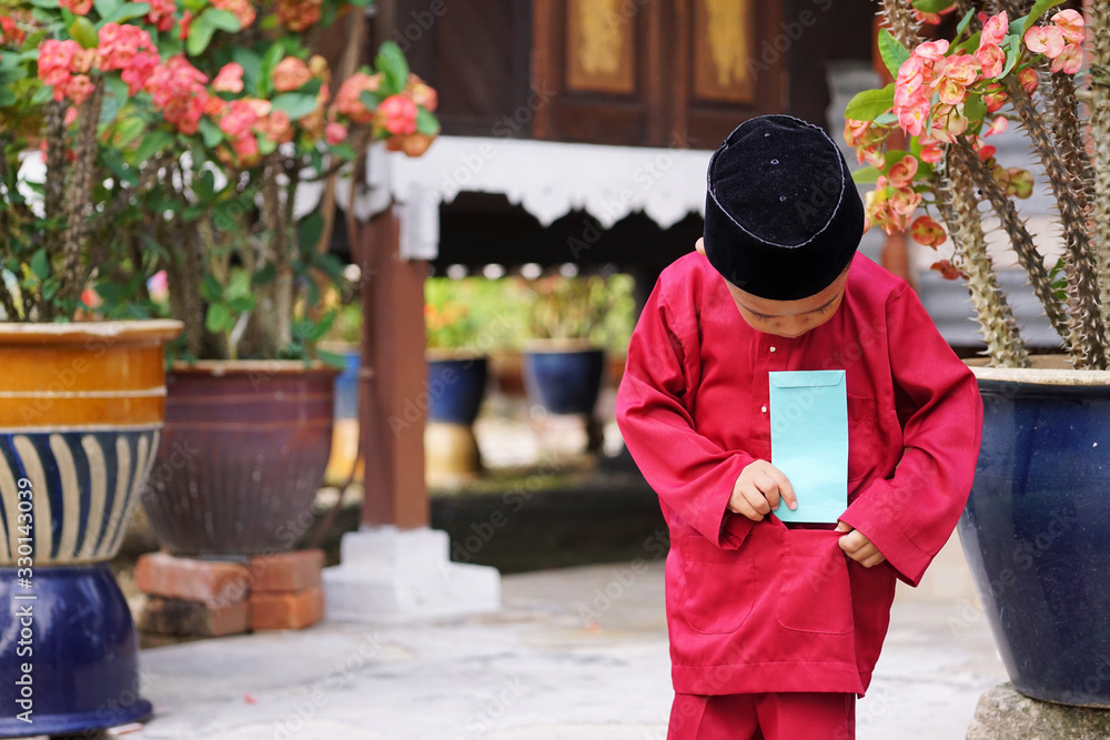 A Malay Boy In Malay Traditional Cloth Showing His Happy Reaction After a-malay-boy-in-malay-traditional-cloth-showing-his-happy-reaction-after