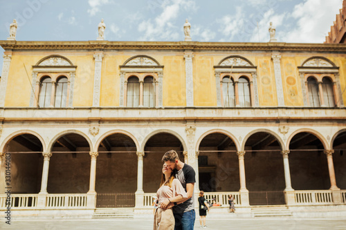 Charming couple, man and woman, hugging the background of the sights of Verona. Travel concept.