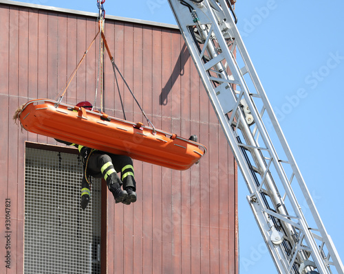 Fototapeta brave firefighter on the stretcher with person