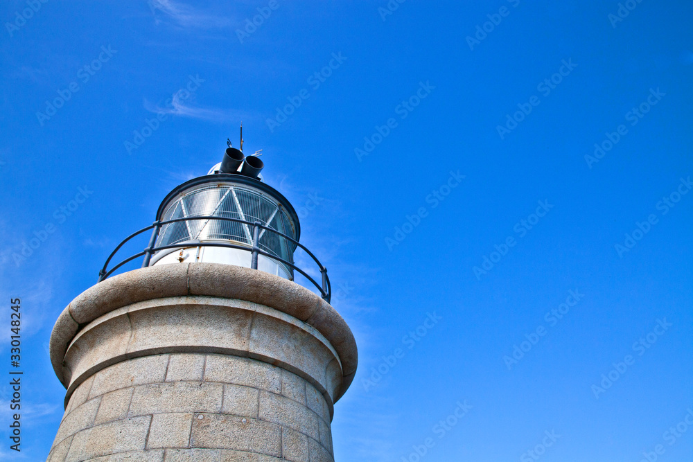 Looking up at the top of a lighthouse with blue skyies