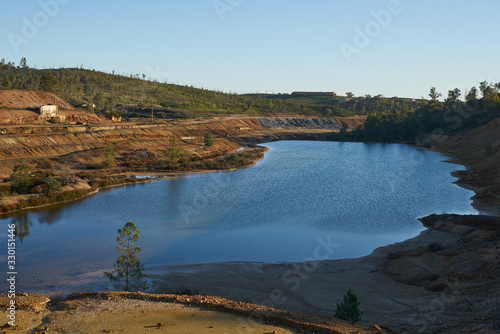Fototapeta Naklejka Na Ścianę i Meble -  Contaminated pond lake of an old abandoned mine red landscape in Mina de Sao Domingos, Portugal